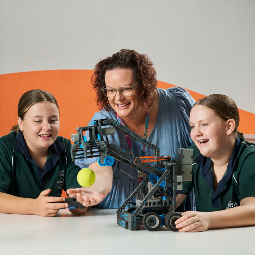 A Faith Lutheran College Teacher helping her students with a robot