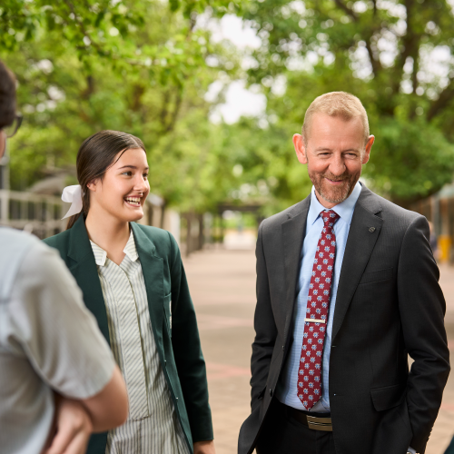 The Principal of Faith Lutheran College smiles whilst talking to his students