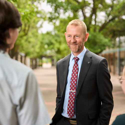 The Principal of Faith Lutheran College smiling whilst talking to his students