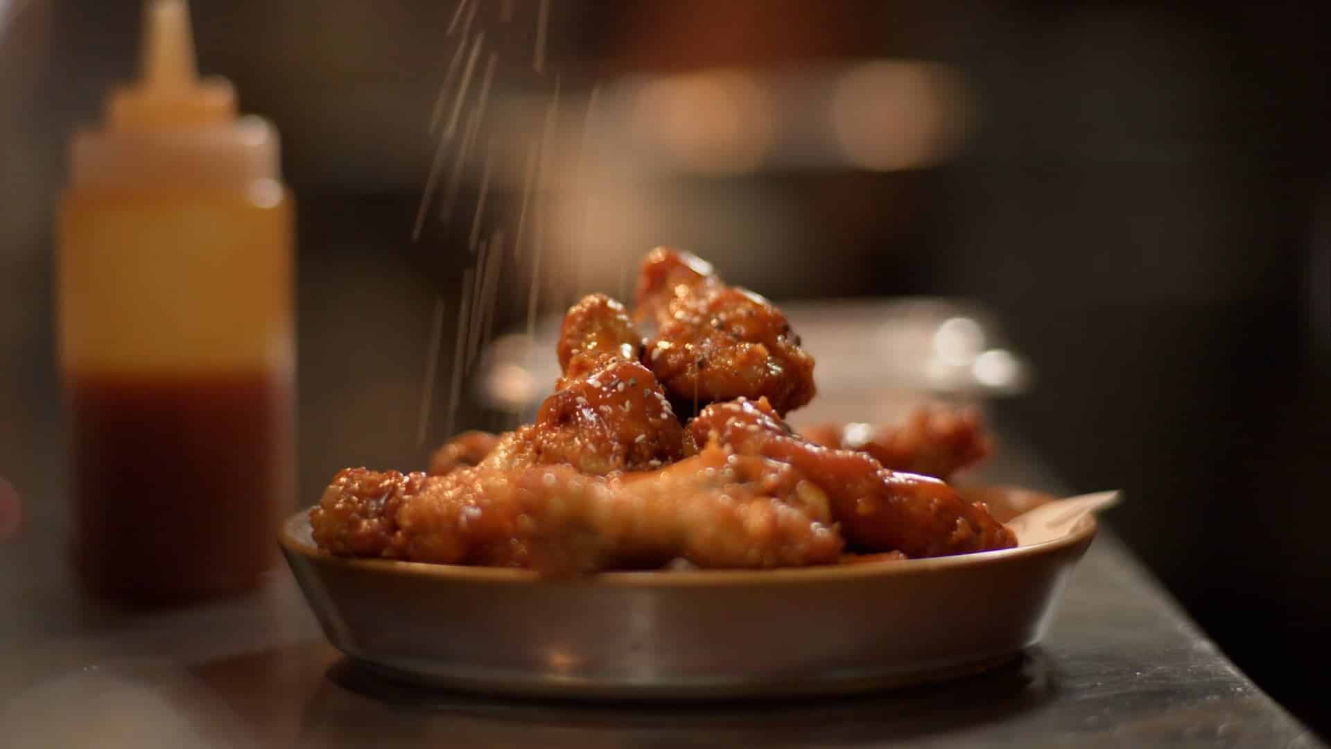 A still taken from the sussex hotel main video that Stepney Studios produced. It pictures a bow of chicken wings being seasoned in the Sussex Hotel kitchen ready to be served.